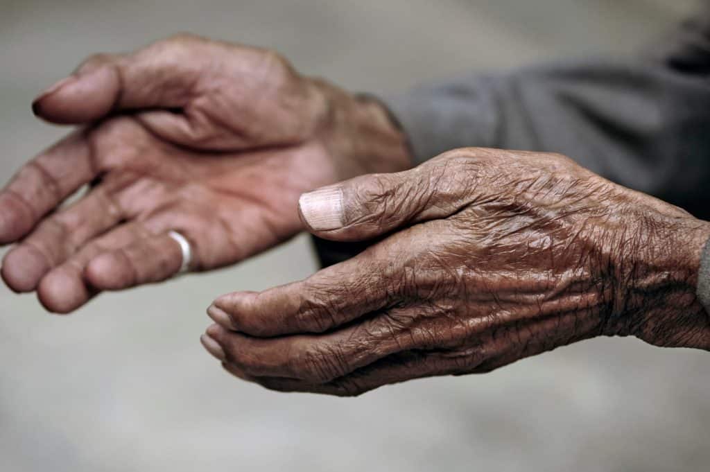 Hands of elderly man begging