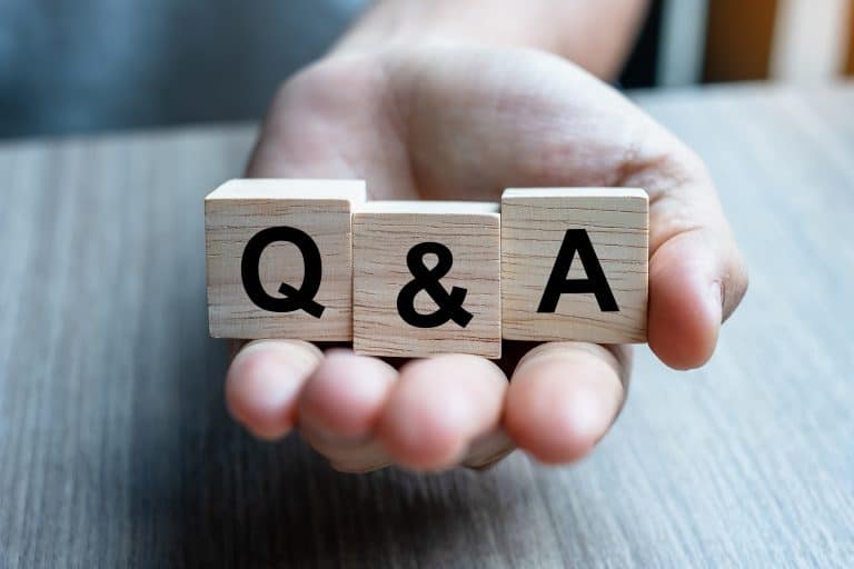 Male hand hand holding Q&A word with wooden cube block