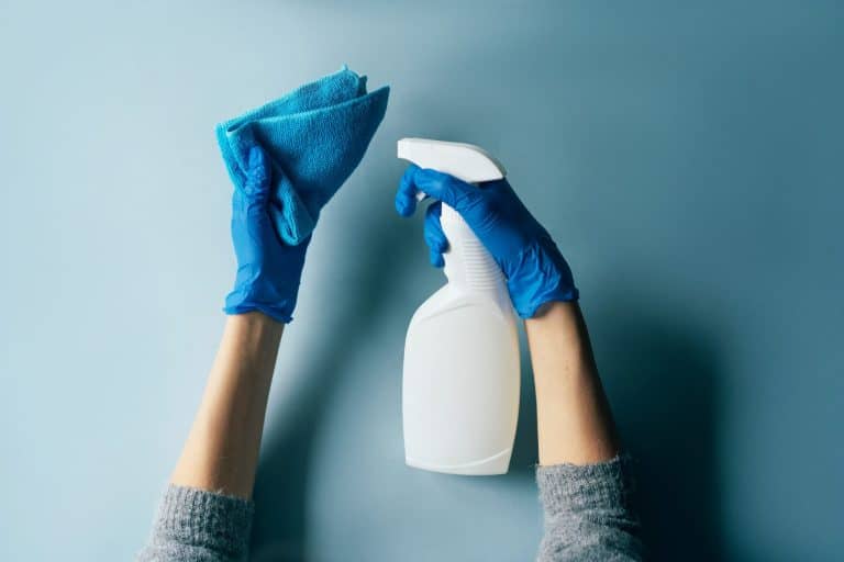 Hands holding towel and disinfectant